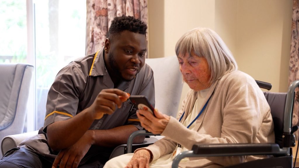 Care Home Marketing Digital, carer with resident on smart phone