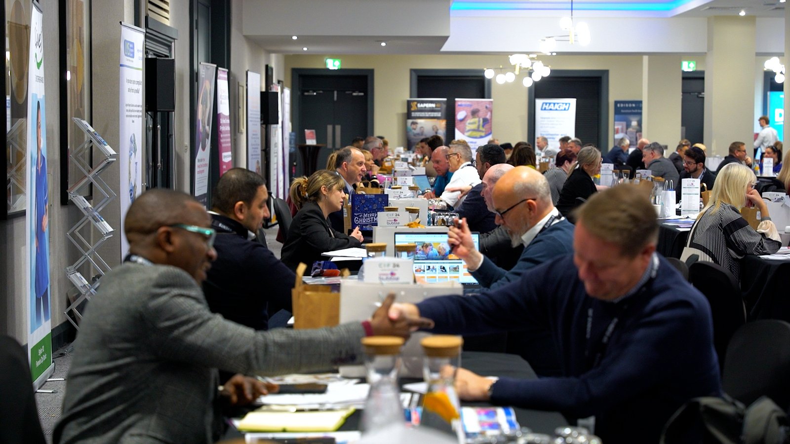 Table meet and greet workshop event suppliers across tables shaking hands
